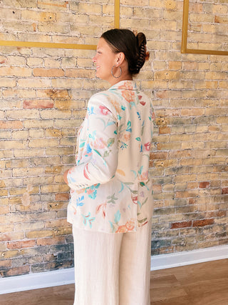 Woman wearing a floral blouse against a brick wall