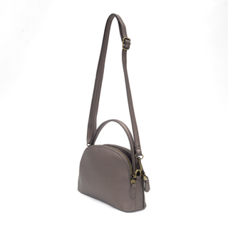 Close-up of adjustable crossbody strap and gold hardware details on the Larissa vegan leather bag. metallic bronze color.