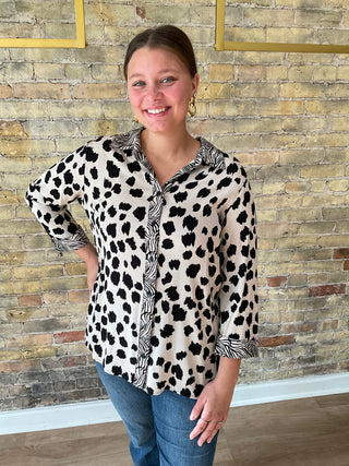 Woman wearing a leopard print shirt with a brick wall background