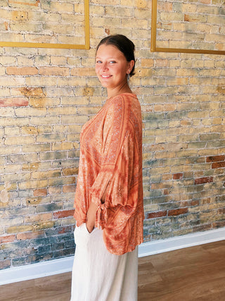 woman wearing a boho paisley print blouse with 7/8 sleeves and relaxed fit. 