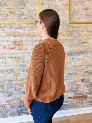 Woman wearing the Ella Sweater, a high neck zip-up ribbed knit sweater styled with denim for a polished casual look