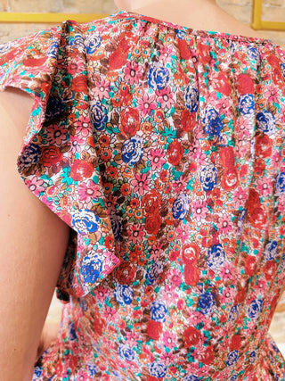 Multicolored floral dress with ruffled sleeves on a blurred background