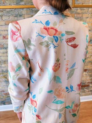 Person wearing a floral-patterned outfit with a brick wall background