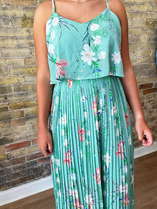 Model wearing mint green floral pleated dress front view


