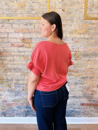 Jill Blouse – textured coral short sleeve top with elastic details on sleeves and flowy cut on the waist.