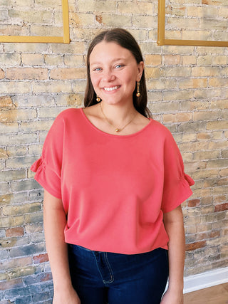 Everly Blouse – textured coral short sleeve top with elastic details on sleeves and flowy cut on the waist.
